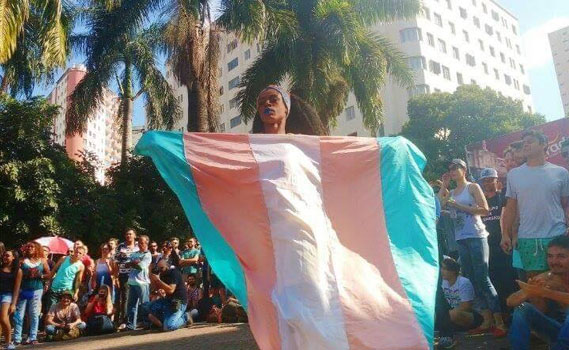 Cristal Lopez segura a bandeira da visibilidade trans.